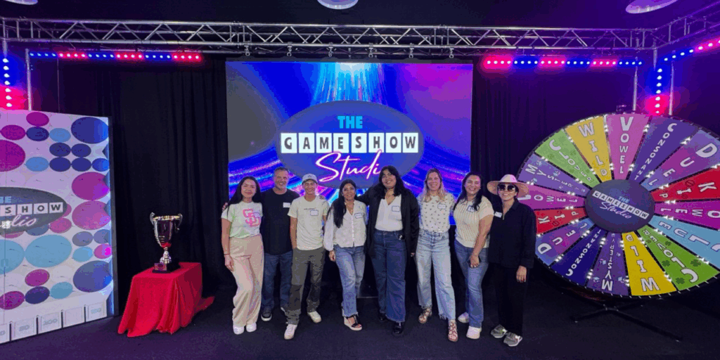 WeLease Property Management San Diego team photo at Game Show Studio in 2025, showcasing company culture, collaboration, and team unity.